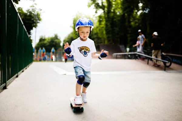Paten parkında paten yapan bir çocuk. Çocuk tam koruma içinde paten kaymayı öğreniyor..
