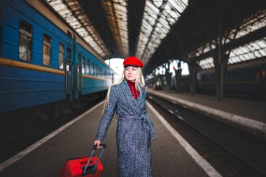 Kırmızı şapkalı ve kırmızı çantalı kadın, şehir geometrisi.