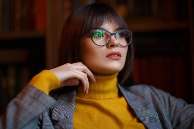 Şık, keskin gözlüklü, rüya gibi güzel bir kız. Kütüphanede..