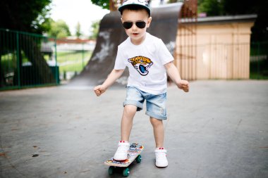 Paten parkında paten yapan bir çocuk. Gözlüklü bir çocuk paten kaymayı öğrenir..