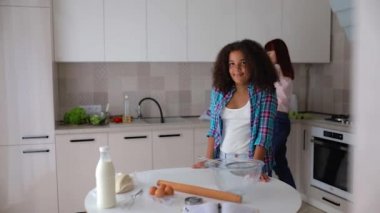 Afro-Amerikalı kız Vanessa ve annesi mutfakta salata hazırlıyorlar..