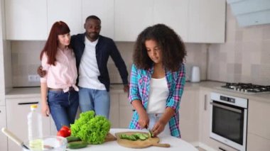 Afrikalı Amerikalı kız Vanessa annesi ve babası mutfakta salata hazırlıyorlar..