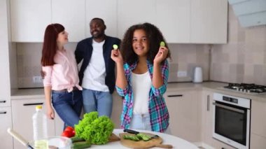 Afrikalı Amerikalı kız Vanessa annesi ve babası mutfakta salata hazırlıyorlar..