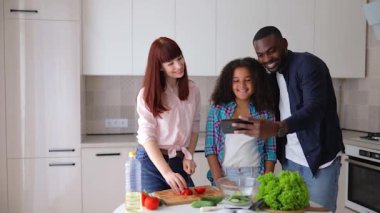 Afrikalı Amerikalı kız Vanessa annesi ve babası mutfakta salata hazırlıyorlar..