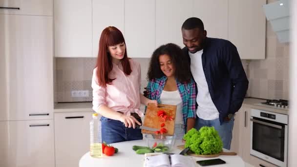 Afroamerikansk jente Vanessa, moren og faren hennes, på kjøkkenet og lagde salat. – stockvideo