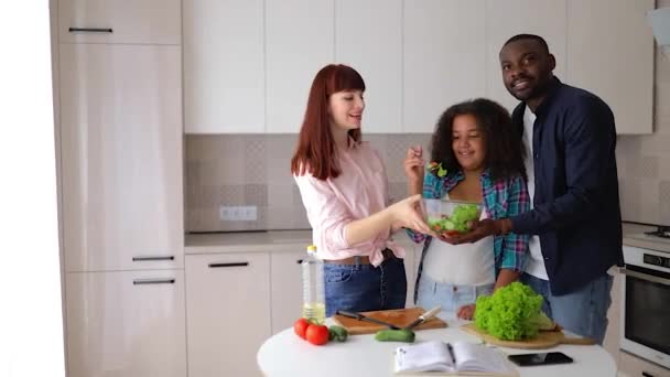 Afroamerykanka Vanessa jej mama i tata w kuchni przygotowuje sałatkę. — Wideo stockowe
