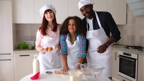 African-American girl Vanessa, her mom and dad in the kitchen, baking cakes. — Stock Video