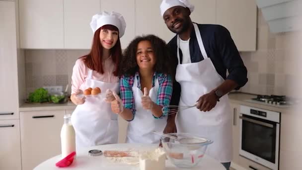 Afroamerikansk jente Vanessa, moren og faren hennes på kjøkkenet, bakekaker. – stockvideo