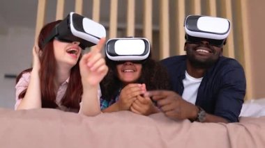 Afro-Amerikalı kız Vanessa, annesi ve babası VR gözlüklü. VR gözlüklü uluslararası aile.