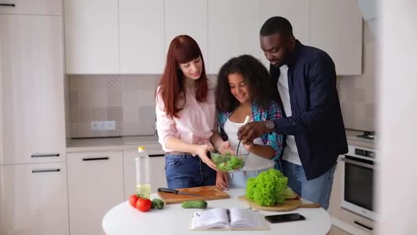 Chica afroamericana Vanessa su mamá y papá en la cocina preparando una ensalada . — Vídeos de Stock