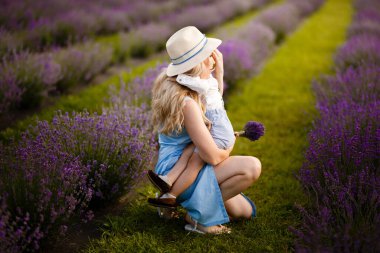 Küçük çocuk annesiyle lavanta tarlasında yürüyor..