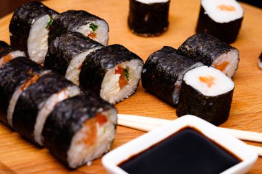 Somonlu suşi. Soya sosu, kırmızı havyar. Siyah arka planda suşi..