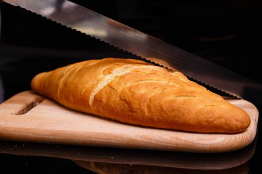 Ev yapımı beyaz ekmek büyük bir bıçakla kesilir. Evde pişirme.