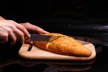 Ev yapımı beyaz ekmek büyük bir bıçakla kesilir. Evde pişirme.