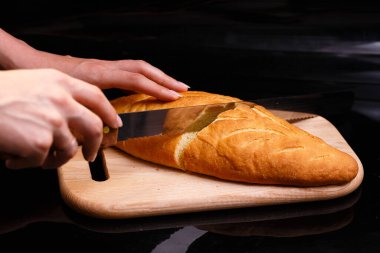 Ev yapımı beyaz ekmek büyük bir bıçakla kesilir. Evde pişirme.