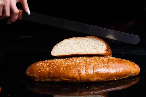 Σπιτικά γλυκά. Τραγανό άσπρο ψωμί κομμένο με μαχαίρι. — Φωτογραφία Αρχείου