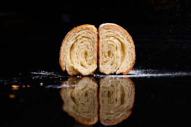 Doldurulmuş kruvasan. Ev yapımı hamur işleri, ikiye bölünmüş kruvasanlar ve üzerine krema serpiştirilmiş..