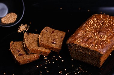 Siyah arka planda ev yapımı siyah ekmek. Fotoğraf: Bölüm.