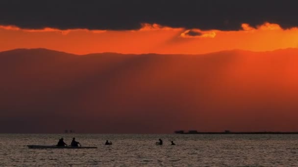 独木舟和贝类钓鱼人在海上和日落剪影 — 图库视频影像