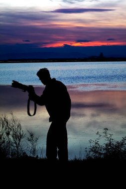 Sahil manzarası yakınında bir fotoğrafçı silueti