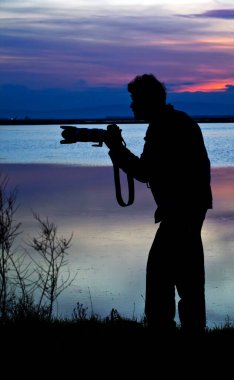 Sahil manzarası yakınında bir fotoğrafçı silueti