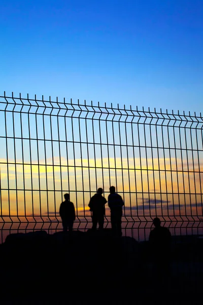 People Silhopuette Grate Fence Afternoon Light — Stock Photo, Image