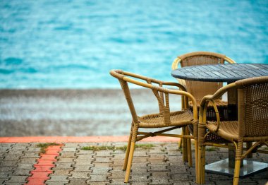 Deniz kenarındaki tatil fotoğrafının yanındaki koltuklar.
