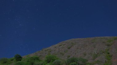 New Caledonia 'da bir tepenin arkasındaki yıldızlı gökyüzünün zamanı