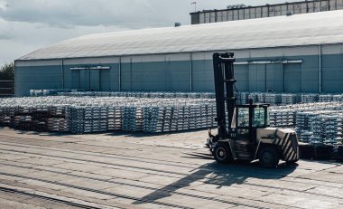 Limanda kargo. İskelede alüminyum gotlar var. Kargo depoları ve gemilerin arka planında
