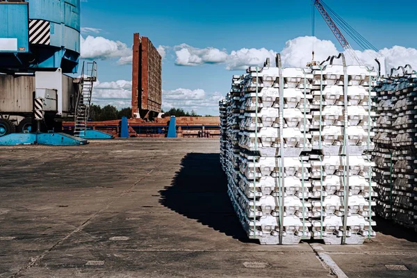Limanda kargo. İskelede alüminyum gotlar var. Kargo depoları ve gemilerin arka planında