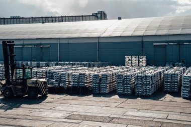 Limanda kargo. İskelede alüminyum gotlar var. Kargo depoları ve gemilerin arka planında