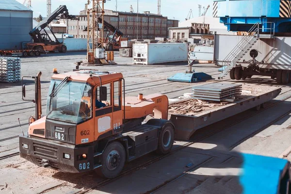 Limanda kargo. İskelede alüminyum gotlar var. Kargo depoları ve gemilerin arka planında