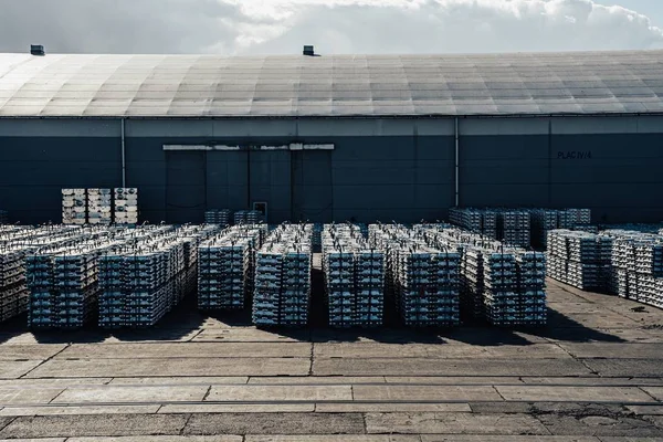 Limanda kargo. İskelede alüminyum gotlar var. Kargo depoları ve gemilerin arka planında