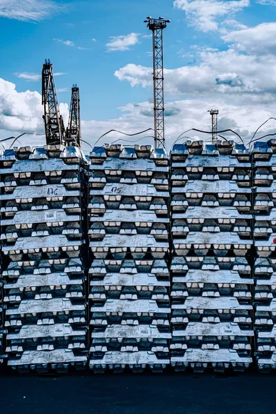 Limanda kargo. İskelede alüminyum gotlar var. Kargo depoları ve gemilerin arka planında