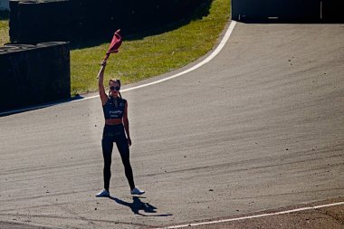 Riga, Letonya - 02 Ağustos 2019 - Koşu galibini belirleyen bayraklı çekici kadın