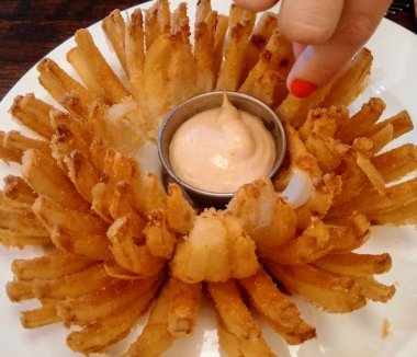 Deep fried chrysanthemum onion with ladies hand and dip clipart