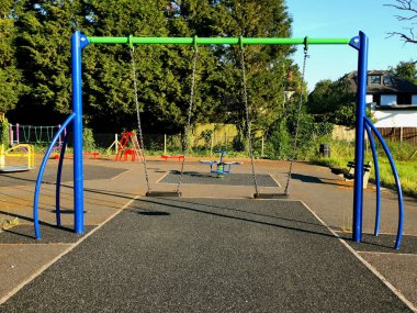 Yerel belediye parkında renkli çocuklar salıncak ve oyun ekipmanları