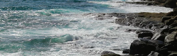 Bella vista di rocce grezze e costa e blu mare schiumoso — Foto Stock