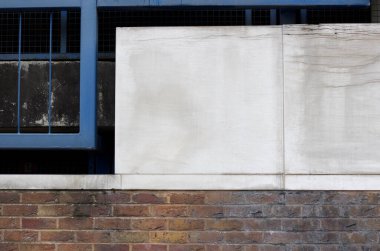 Duvarın üzerinde metal çerçeve ile kirli paneller var.