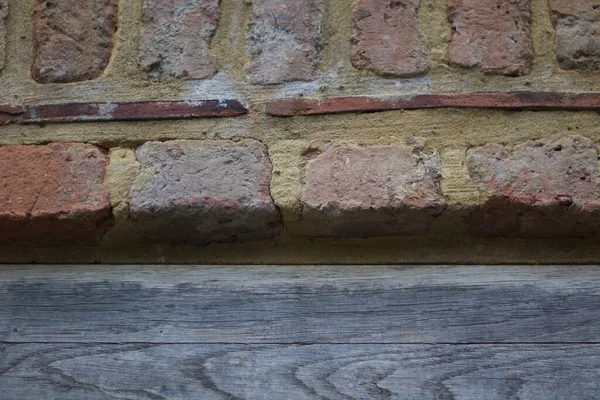 Background showing contrasting weathered wood with pointed old brickwork above — Stock Photo, Image