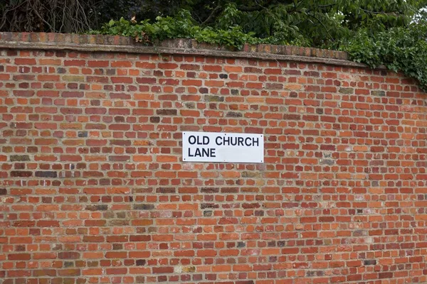 18 Julho 2020 - Inglaterra, Reino Unido: Sinal de estrada para Old Church Lane na parede de tijolos — Fotografia de Stock