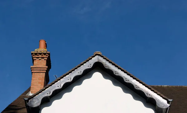 Крыша викторианского дома с софитами и украшенным кирпичом, построенным дымоходом — стоковое фото
