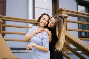 Mutlu yaşlı anne yetişkin kızı kucaklayan, birlikte gülüyor, gülen bayan, sarılma genç kadın, farklı yaş nesillerin samimi aile, konuşma, şaka, eğlenceli. Mutlu bir aile kavramı