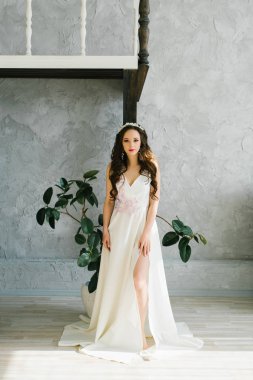 Gelinin sabahı. Güzel bir gelin gelinlik içinde duruyor. Çiçeklerle giyin, bacağından bir kesik. Klasik Stüdyo