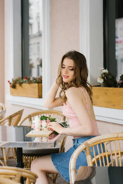 Ένα Όμορφο Κορίτσι Κάθεται Ένα Τραπέζι Ένα Καφέ Αυτή Σήκωσε — Φωτογραφία Αρχείου