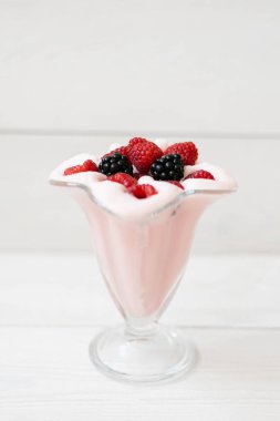 Güzel pembe ahududu snack meyve smoothie veya milkshake beyaz bir kalas üzerinde ahududu ve böğürtlen ile bir bardak . Yoğurt kokteyli. Doğal detoksifikasyon.