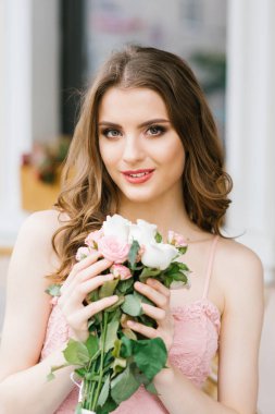 Elinde gül bir buket ile güzel bir gülümseyen kız Yaz portresi. profesyonel makyaj