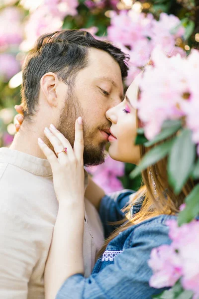 Sensual couple kiss. Romantic love relationship. Tenderness of the feelings of a girl and a guy. Passion and sensual touch in spring in blooming gardens.  I love you. loving couple.