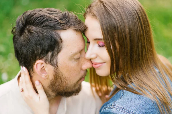 Sensual young couple enjoys a gentle warm pleasant moment of love having a romantic date, pressed their noses and foreheads, enjoy each other