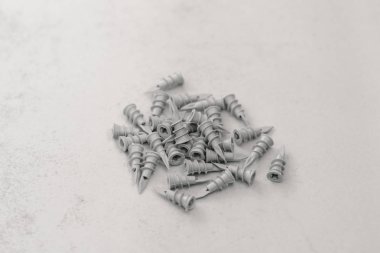 Alçıpan vidaları için gri plastik kaplamalar gri bir arka planda. İnşaat için Fasters.